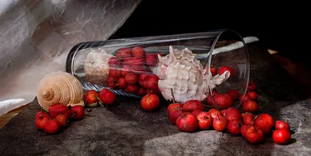 Fresh strawberries on table with green bottle background