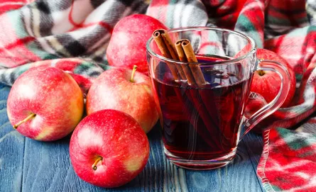 Red apples with cinnamon sticks in drink