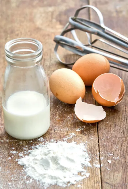 Breaking egg with spoon on table