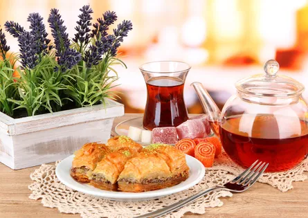 Purple flowers, tea and dessert on table
