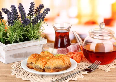 Purple flowers, tea and dessert on table