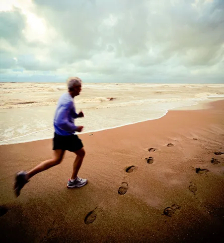 Old man running on beach