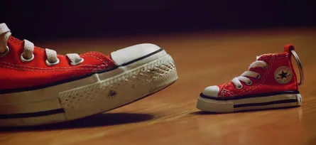 Small red shoes next to large red shoes