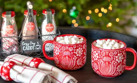 Mugs on table, christmas tree in background