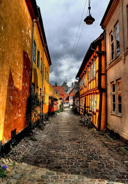 Cobblestone street, yellow building, gray sky