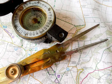 Old compass and scissors on map