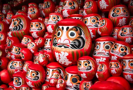 Row of red vases with gold accents and faces