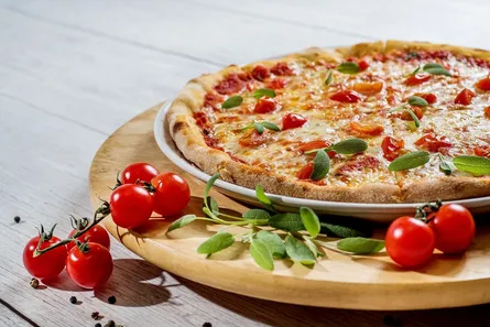 Uncooked pizza on wooden table