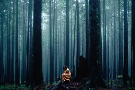Woman sitting alone in woods