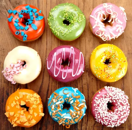 Colorful doughnuts on wooden surface