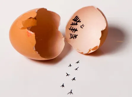 Cracked egg with drawing of stick figures and cracks on the right side