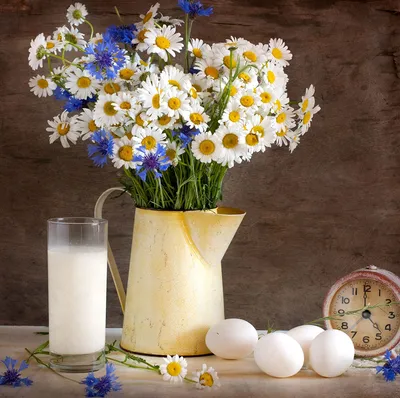 Flowers, milk jug, eggs on table