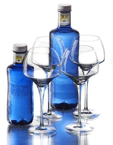 Three wine glasses and two bottles
