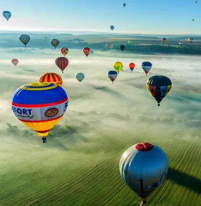 Multiple colorful hot air balloons, daytime flight