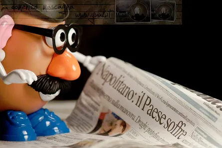 A figure of mr potato reading news paper