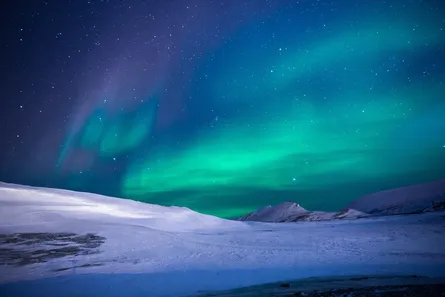 Aurora lights above snowy mountains