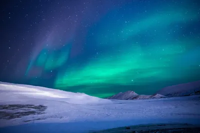 Aurora lights above snowy mountains