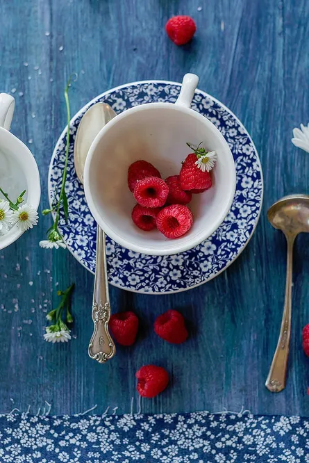 Red berries, blue teacup, strawberries on plate