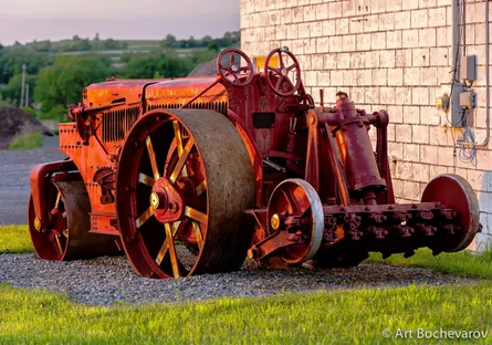 Red tractor parked near building