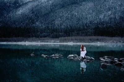 Girl in black and white photo at water's edge