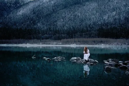 Girl in black and white photo at water's edge