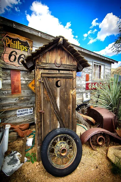 Abandoned outhouse with tire
