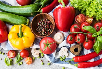 Fresh produce photo, red peppers, green cucumbers, blue and white tablecloth