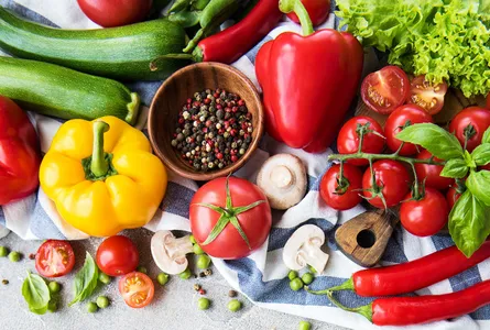 Fresh produce photo, red peppers, green cucumbers, blue and white tablecloth