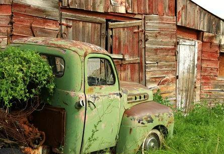 Abandoned truck near barn