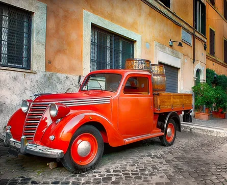 Old red truck on cobblestone street