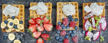 Strawberries, bananas, blueberries and whipped cream waffles